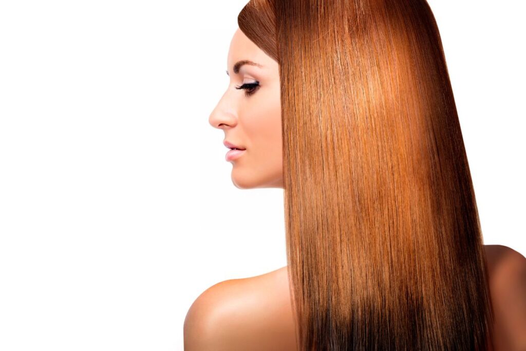 Profilo di donna con capelli rame lisci e lucenti dopo la laminazione