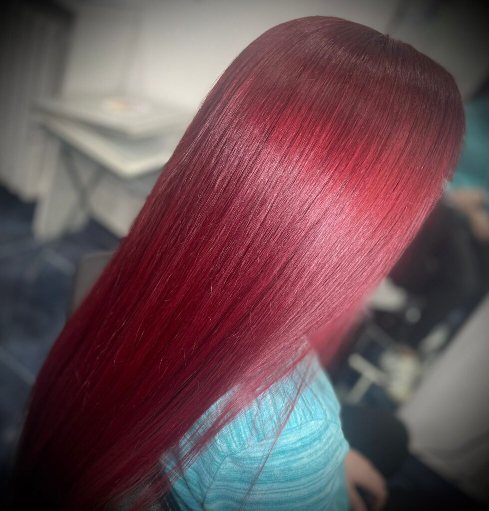 Primo piano di capelli rosso rubino lisci e lucidi dopo trattamento anticrespo