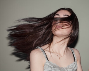 Donna con capelli scuri lisci e lucenti in movimento